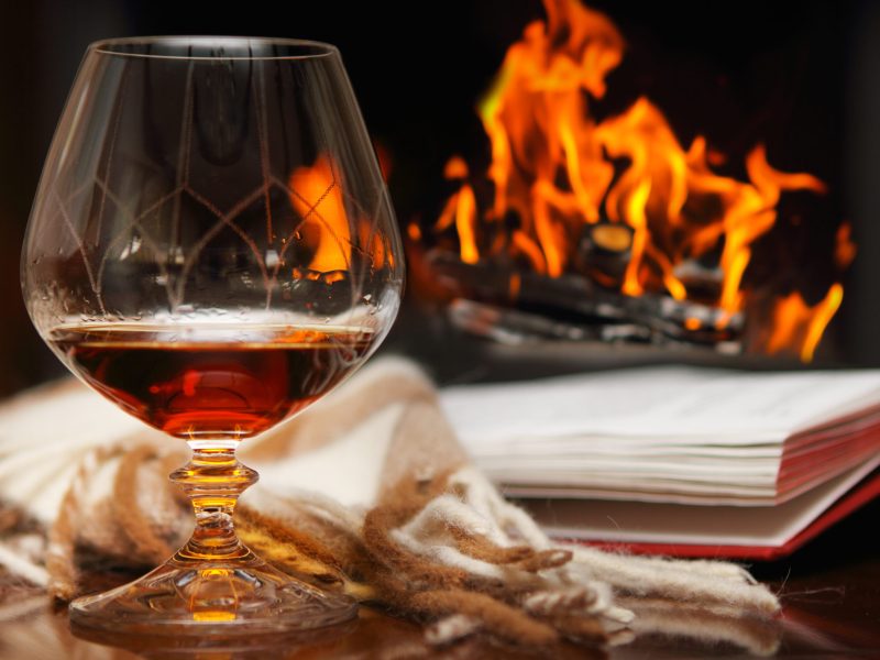 Cognac, book and shawl by the fireplace
